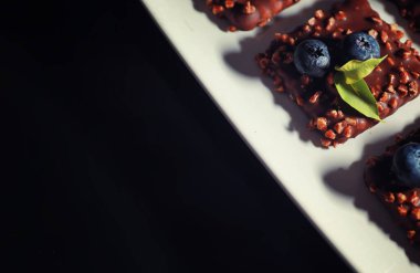 Fındıklı ve dutlu çikolatalı tatlı. Jöleli kahve bisküvisi ve meyveli fındık kırıntıları için tatlı atıştırmalık..