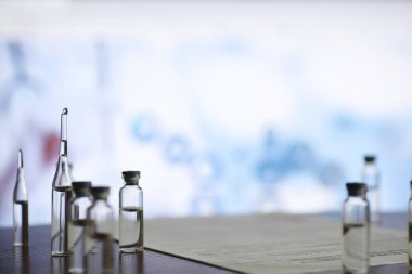 Bir adam tıbbi belge imzalıyor. Tıbbi ekipmanlar masada. Stetoskop ve şırıngalı ampuller. Ofiste notlar alıyor. Tıp Merkezi.