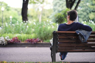 Genç bir adam öğle yemeği zamanında parkta yürür. Bir adam şehirde gezintiye çıktı. Park eden bir öğrenci.