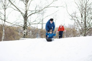Kışın parktaki çocuklar. Çocuklar parkta karla oynarlar. Kardan adam heykeli yapıp tepelerden aşağı kayıyorlar..
