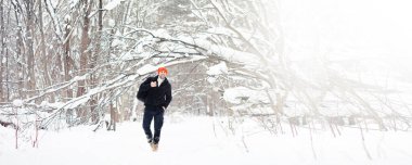 Kışın ormanda bir adam. Sırt çantalı bir turist kışın ormana gider..