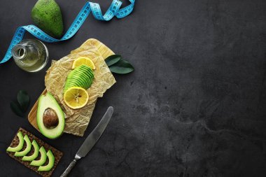 Avokado yemek tarifleri. Tahta kesme tahtasında servis edilen olgun yeşil avokado..