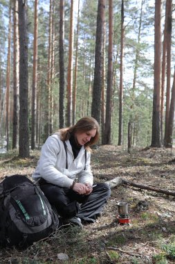 Bir adam bir kampanyada çay içer. Genç bir gezgin ormanda kamp ve kahvaltı doğada pişirilir. Doğa bilimci açık ateşte pişmiş sıcak taze çay içer