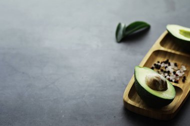 Avokado yemek tarifleri. Tahta kesme tahtasında servis edilen olgun yeşil avokado..