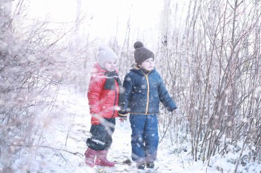 Çocuklar parkta ilk karla yürür.