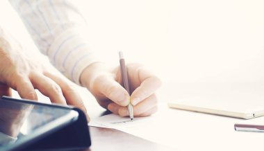 İş toplantısı. Bir adam kontrat imzalar. Erkek ve kalem ofiste notlar alır..