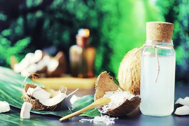 Hindistan cevizi koyu taş bir masada. Hindistan cevizi yağı ve kaşık.