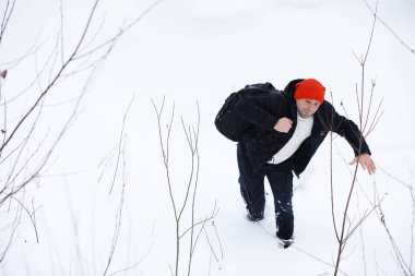 Kışın ormanda bir adam. Sırt çantalı bir turist kışın ormana gider..