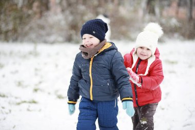 Kışın parktaki çocuklar sno ile oynarlar.