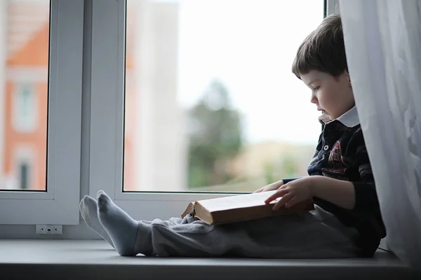 Mały Chłopiec Jest Czytanie Książki Dziecko Siedzi Oknie Przygotowuje Się — Zdjęcie stockowe