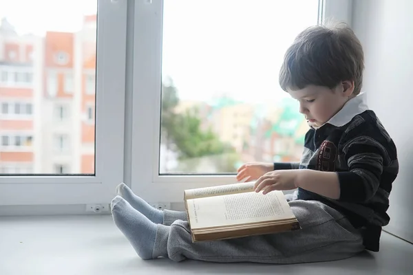 Mały Chłopiec Jest Czytanie Książki Dziecko Siedzi Oknie Przygotowuje Się — Zdjęcie stockowe
