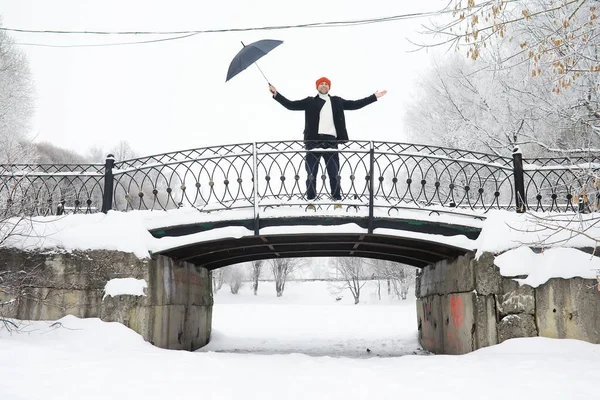 Winter walk with an umbrella.Man in coat with an umbrella, walk against the backdrop of the winter landscape, winter view