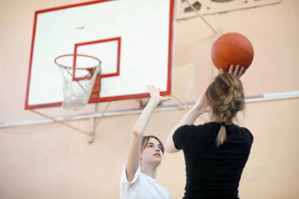体育館でバスケットボールをしている女子学生は — ストック写真