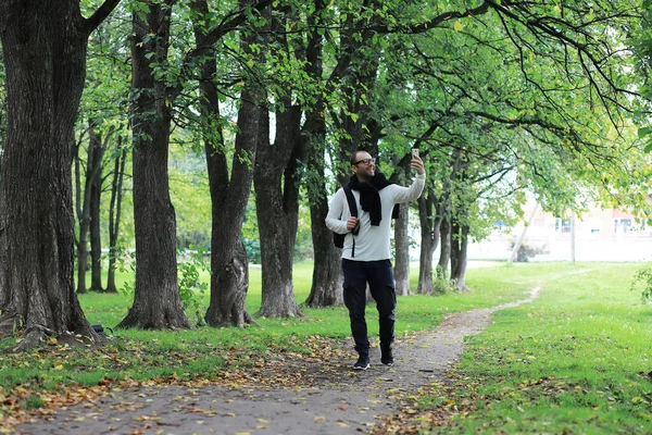 Egy Szemüveges Fiatalember Sétál Parkban Esernyővel Esőben — Stock Fotó