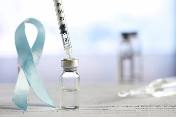 A man signs a medical document. Medical equipment on the table. Stethoscope and ampoules with syringes. Makes notes in office. Medical center.