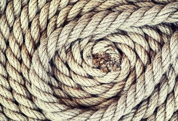 Braided thick rope tied in a skein. Hemp rope for decoration and design. Background from fishing rope.