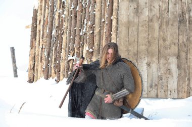 Defender'ı posta zırh genç savaşçı bir kılıç ve balta ile silahlı