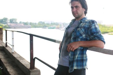 Bir adam sakallı ve kot pantolon endüstriyel bölgede standları