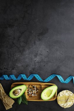 Avokado yemek tarifleri. Tahta kesme tahtasında servis edilen olgun yeşil avokado..