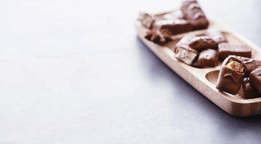 Arkaplanda siyah arka planda çikolatalar. Doldurulmuş çikolata. Atıştırmalık tatlı ve çay.