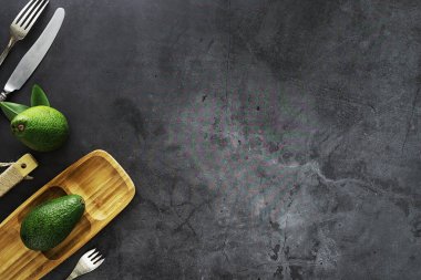 Avokado yemek tarifleri. Tahta kesme tahtasında servis edilen olgun yeşil avokado..