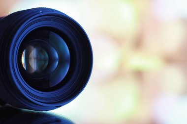 Ekipman kameramanı ve fotoğrafçı. Masadaki lensler parlak lambaların arka planına karşı. Kamera camının yansımasında parla ve bokeh.