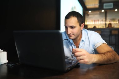 Kafede dizüstü bilgisayarın arkasında çalışan Ermeni yakışıklı adam.