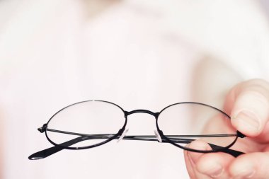 Kötü görüş kavramı. Kontak lens ve gözlüğü elinizde tutun. Reklam gözlükleri ve lensler için poster.