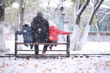 Çocuklar parkta ilk karla yürür.