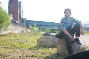 Bir adam sakallı ve kot pantolon endüstriyel bölgede standları