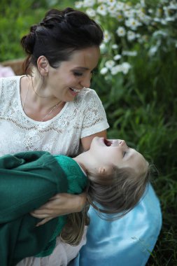 Genç anne kızıyla parkta piknikte.