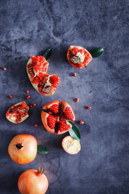 Olgunlaşmış kırmızı nar. Masanın üzerinde olgun nar taneleri var. Nar suyu..