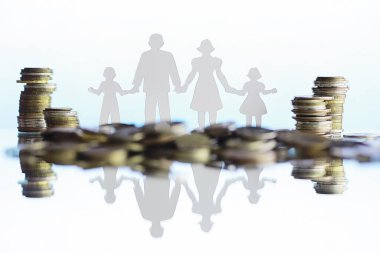 Dört kişilik siluet ve yığınla para. Aile kavramı. Aile bütçesi. Tasarruf yatırımı.
