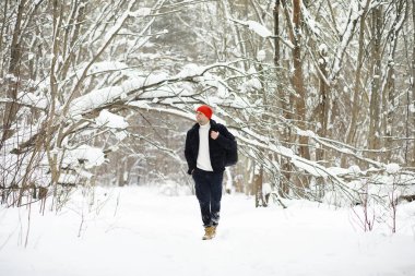 Kışın ormanda bir adam. Sırt çantalı bir turist kışın ormana gider..