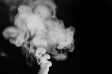 Siyah arka planda beyaz duman. Duman dokusu. Overla için arka planda beyaz duman kümeleri