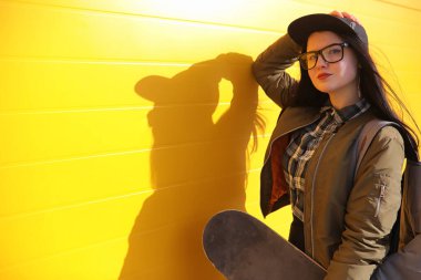 Genç hippi kız bir kaykay sürme. Kızlar kız şehirde bir kaykay ile yürüyüşe. Bahar spor bir kaykay ile sokakta