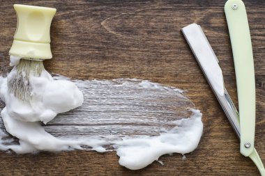 Ahşap dokuda tıraş aksesuarları. Aletler. Tek kullanımlık tıraş makinesi, fırça, köpük tehlikeli tıraş makinesi..