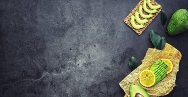 Avokado yemek tarifleri. Tahta kesme tahtasında servis edilen olgun yeşil avokado..