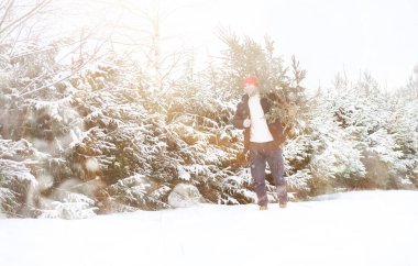 Karla kaplı sokakta Noel ağacı kesen bir adam. Yeni yıl için hazırlık.