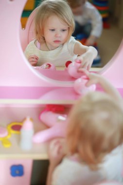 Küçük bir çocuk oyuncakla oynuyor.