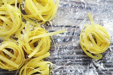 Masada pişmemiş makarna. Yuva şeklinde erişteler. Un ve baharatlar.