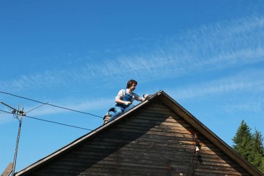 İnşaatçı kılığındaki bir adam bir evi tamir eder.