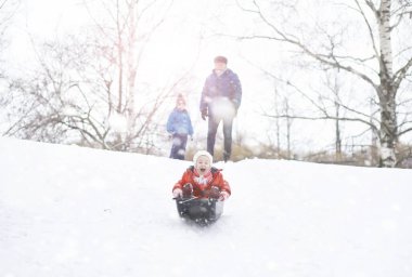 Kışın parktaki çocuklar. Çocuklar parkta karla oynarlar. Kardan adam heykeli yapıp tepelerden aşağı kayıyorlar..