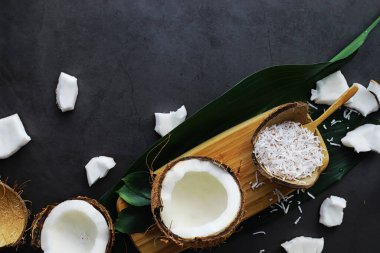 Hindistan cevizi koyu taş bir masada. Hindistan cevizi yağı ve cips.