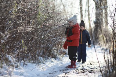 Kışın parktaki çocuklar sno ile oynarlar.
