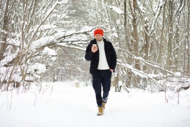 Kışın ormanda bir adam. Sırt çantalı bir turist kışın ormana gider..