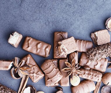 Arkaplanda siyah arka planda çikolatalar. Doldurulmuş çikolata. Atıştırmalık tatlı ve çay.