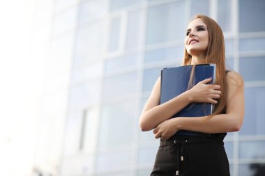 Modern bir binanın yakınındaki bir iş toplantısında belgeli bir kız.