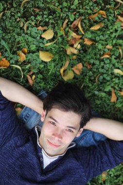 Genç bir adam öğle yemeği zamanında parkta yürür. Bir adam şehirde gezintiye çıktı. Park eden bir öğrenci.