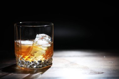 Tahta tezgahta buzlu sert bir alkollü içecek. Buzlu viski alayım. Bardakla soğuk bir içecek..